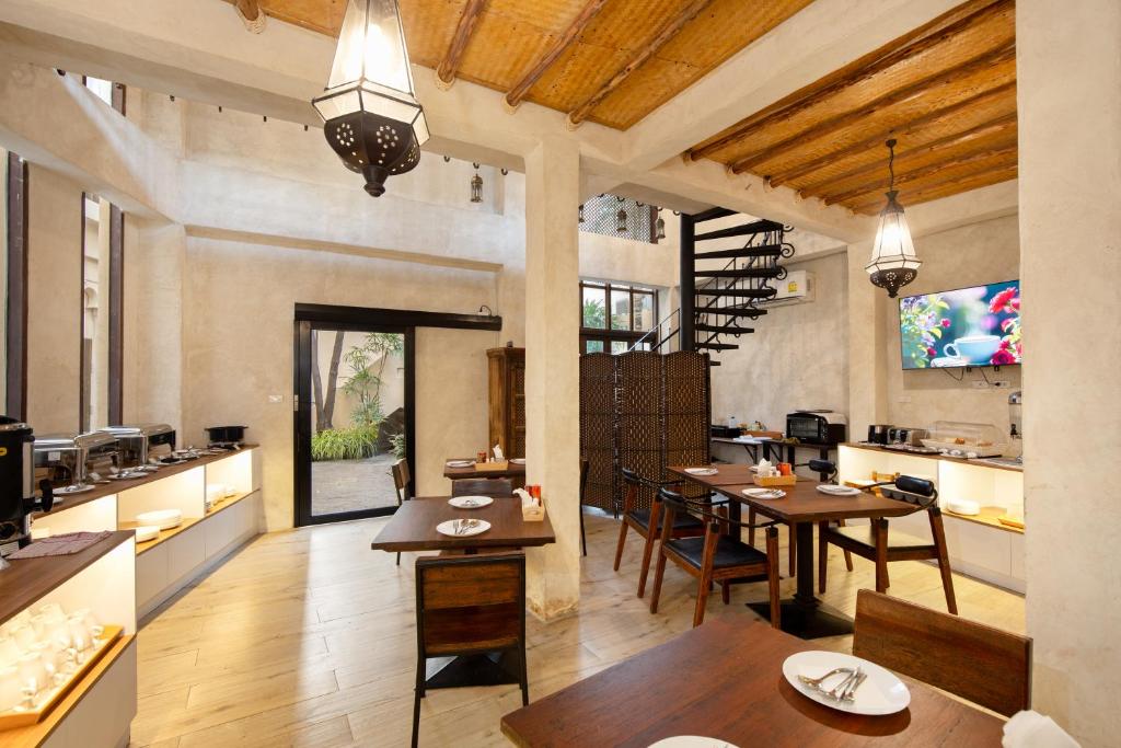 A traditional dining room with buffet counters, set tables, and a garden doorway.