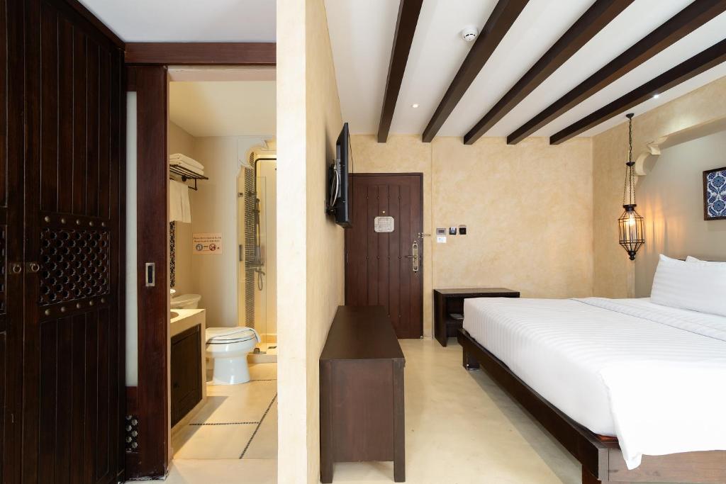 A traditional-style bedroom with an adjoining bathroom entrance.