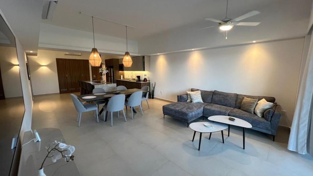 a living room with a couch and a table and chairs at Departamento TerraMar Flamingos in Nuevo Vallarta