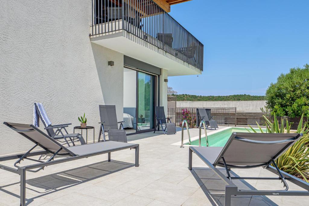 un patio avec des chaises et une piscine dans l'établissement Mirtina Home, à Golfo Aranci