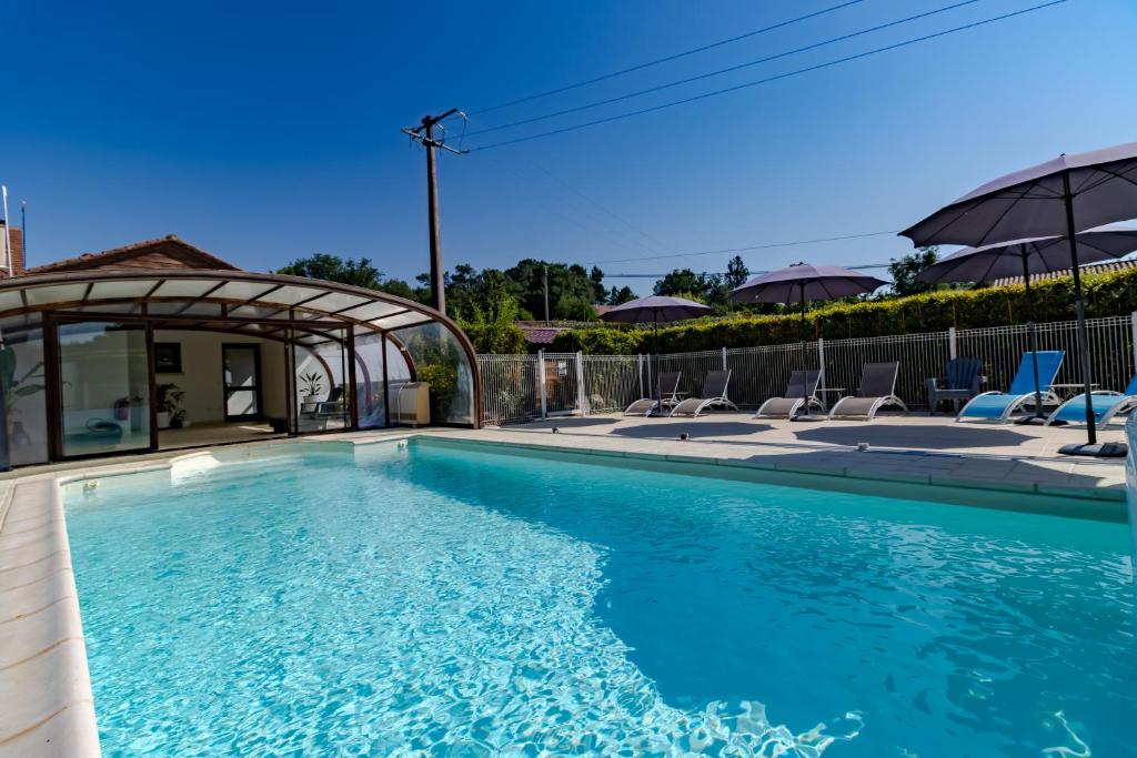 a swimming pool in a yard with chairs at Maison Liz in Castelnaud La Chapelle