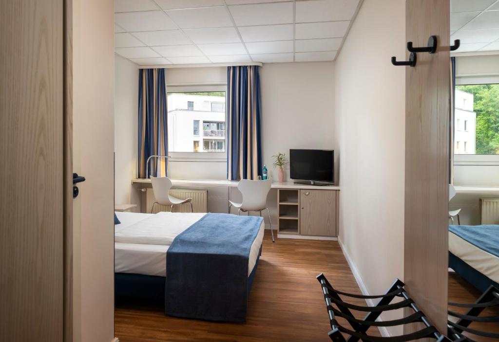 Postel nebo postele na pokoji v ubytování NOVALIS Hotel by AURUM Dresden