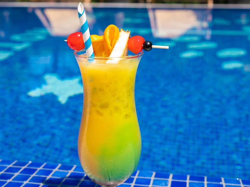 a drink with oranges and cherries and a straw at The Hotel Unforgettable - Hotel Tiliana by Homoky Hotels & Spa in Budapest