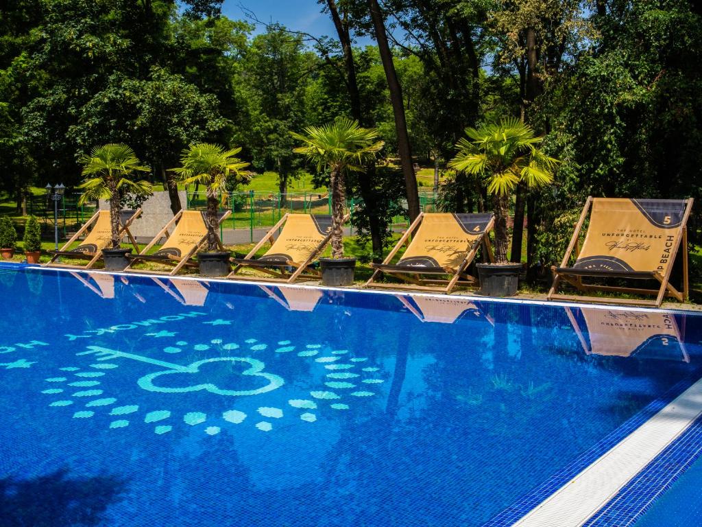 a row of lounge chairs sitting next to a swimming pool at The Hotel Unforgettable - Hotel Tiliana by Homoky Hotels & Spa in Budapest