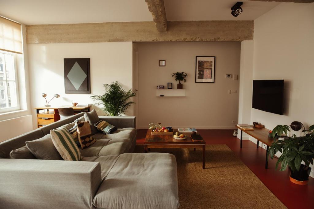 un soggiorno con un divano e un tavolo di Aplace Antwerp - marvellous flats & hotel rooms - Leeuwenstraat 20 ad Anversa