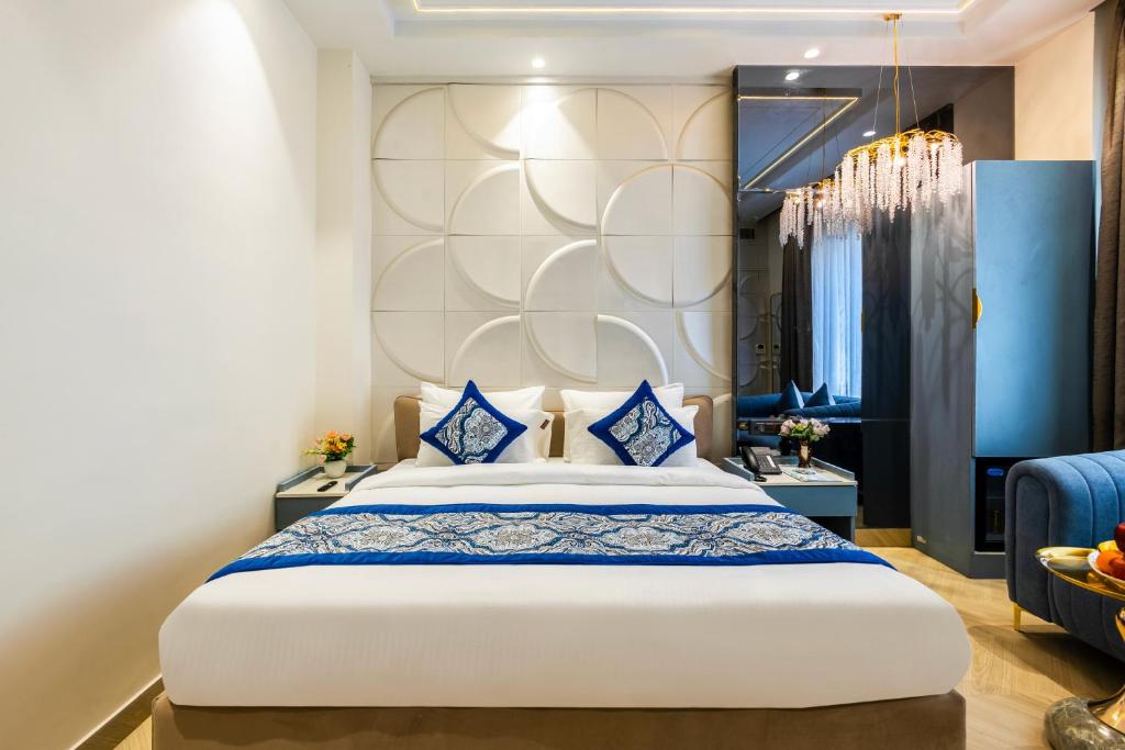 een slaapkamer met een groot wit bed met blauwe kussens bij The Bella Express- New Delhi in New Delhi