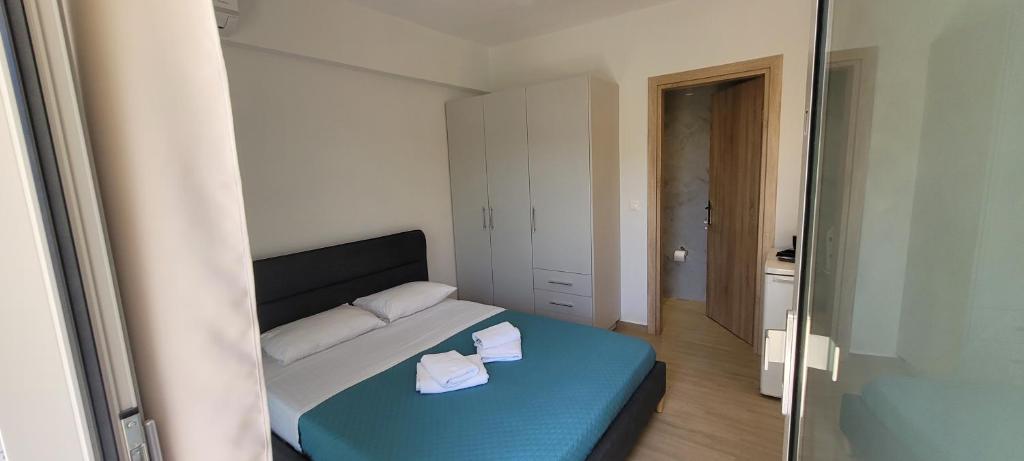 a bedroom with a blue bed with two pillows at Vasiliki Apts in Vasiliki