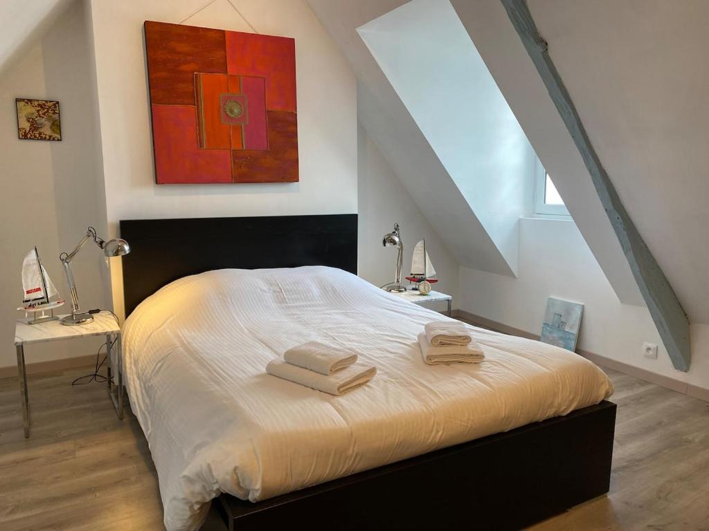 Un dormitorio con una cama con dos toallas encima. en Le Parvis, en Granville