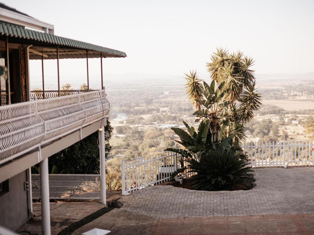 a balcony of a house with a palm tree at Kudu Kopje Lodge in Kroondal