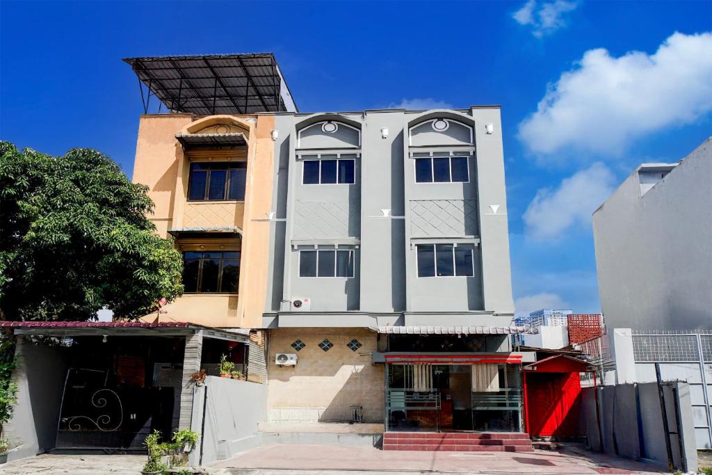 a tall white building with a lot of windows at Dancenter Waringin Residence in Medan