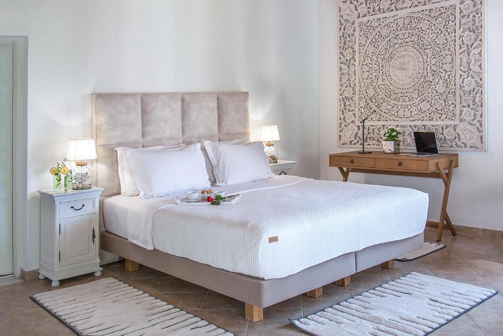 a bedroom with a large white bed and a table at Georgia Villas in Skiathos