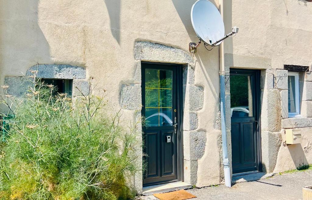 a house with a blue door and a mirror at Chez Ulysse studio entièrement rénové et au calme in Ussel