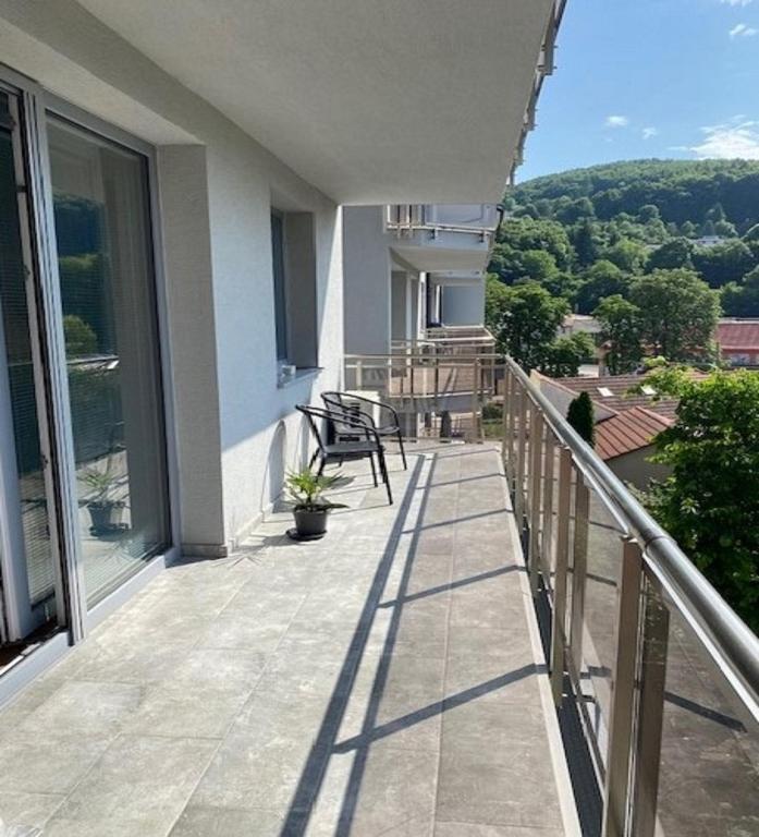 a balcony of a house with a table and chairs at RELAX apartmán Trenčianske Teplice in Martinske Hole