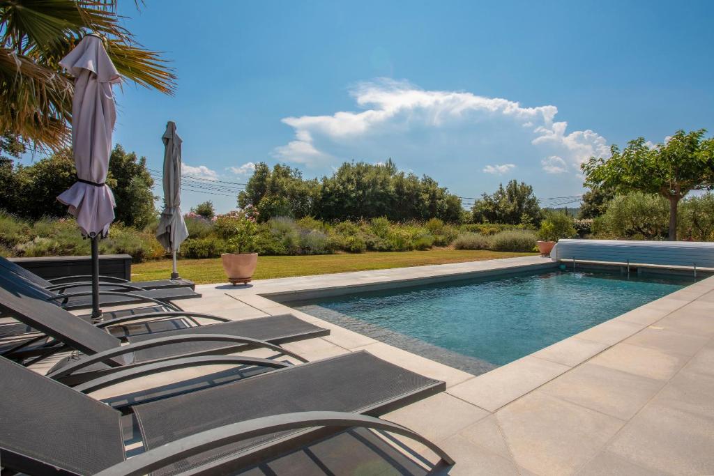 une piscine avec des chaises et un parasol dans l'établissement Studio 890, à Lorgues
