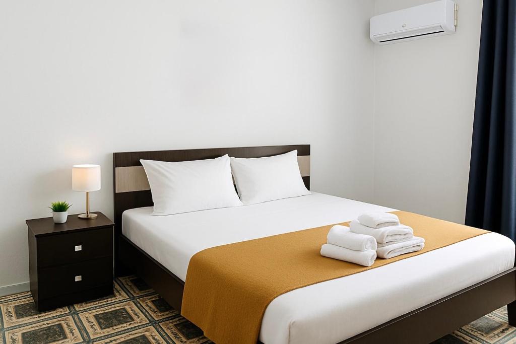 una camera da letto con un letto con asciugamani sopra di Vila Elite a Ksamil