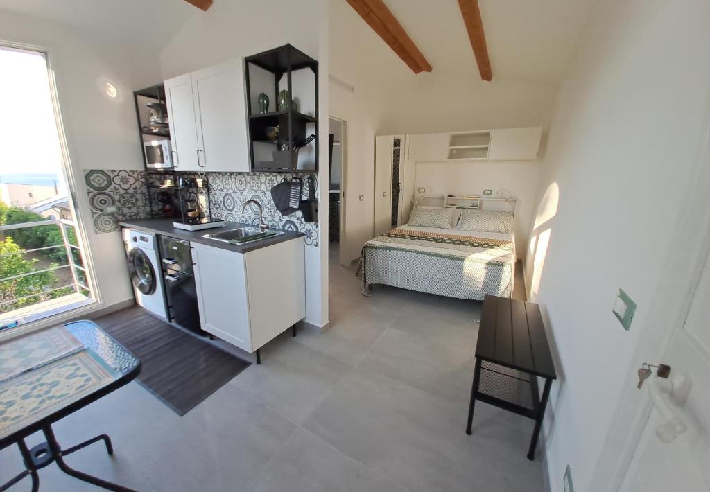 uma cozinha com uma pia e uma cama em um quarto em MonoMare em Avola