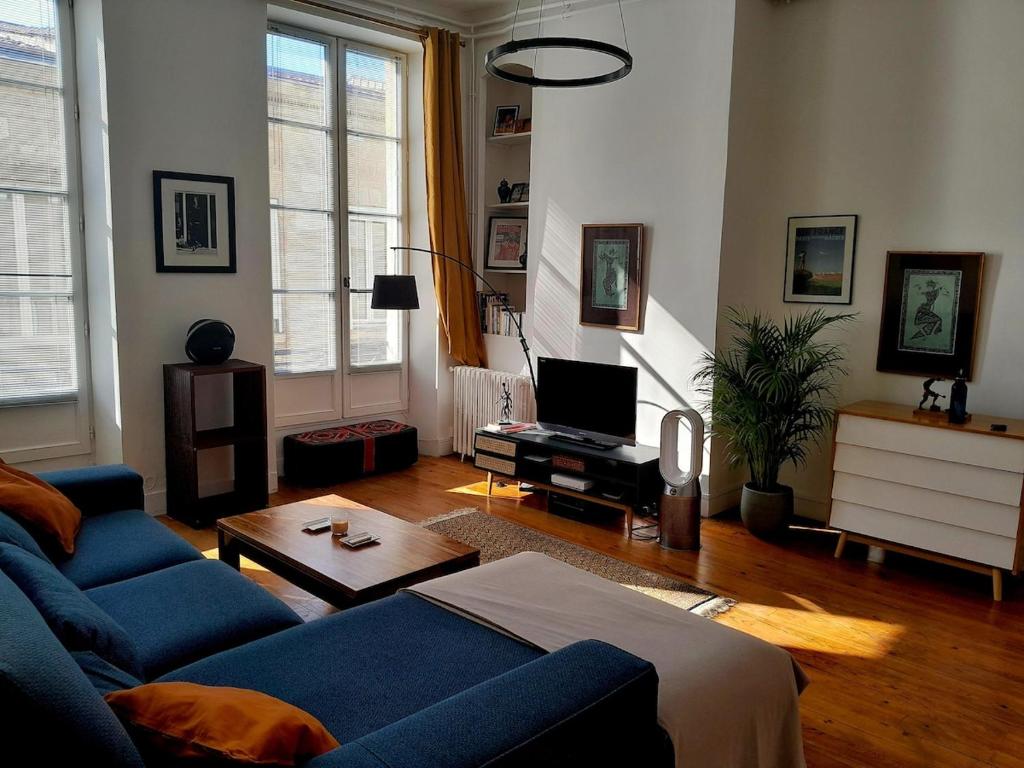 a living room with a blue couch and a table at L'appartement idéal in Bordeaux