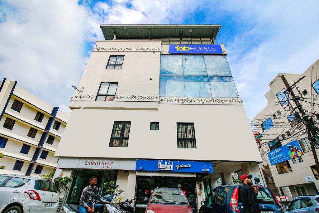 a tall building with cars parked in front of it at FabHotel Smriti Star in Bhopal