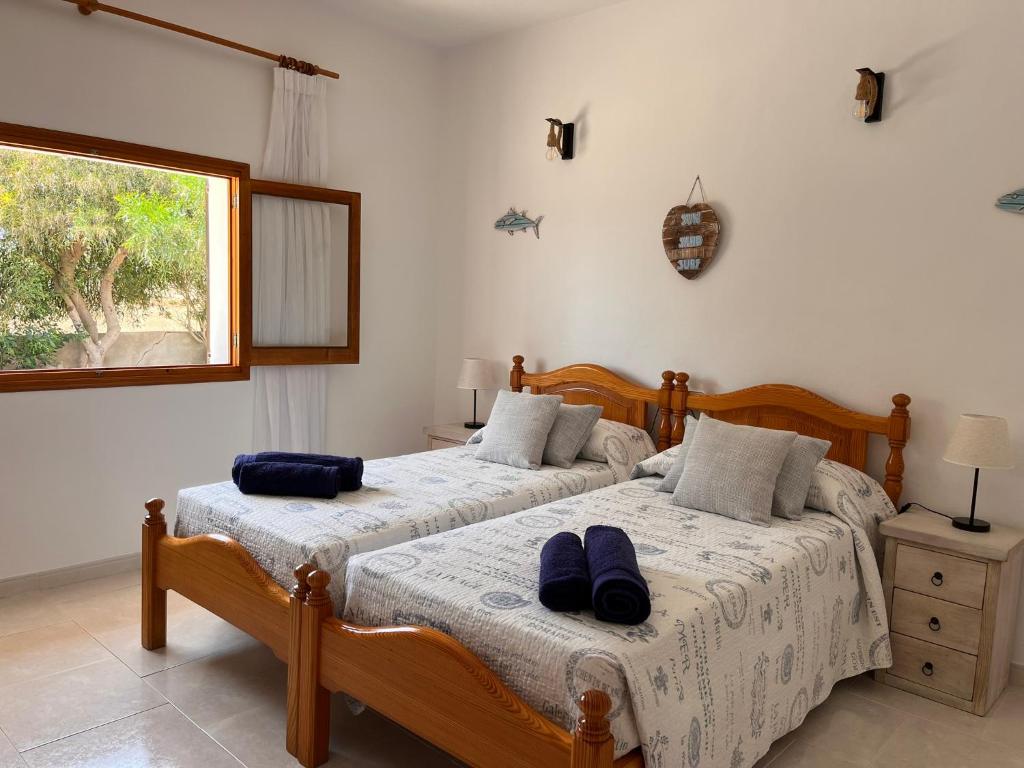 a bedroom with two beds and a window at Can Mariano Mayans in Sant Francesc Xavier