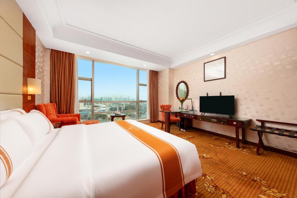a hotel room with a large bed and a television at Shenzhen Xili Nanrong Hotel in Shenzhen