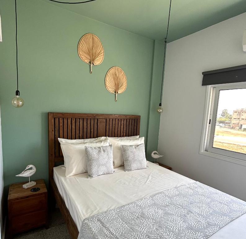 a bedroom with a bed with white sheets and two lamps at Olive Bloom in Larnaka