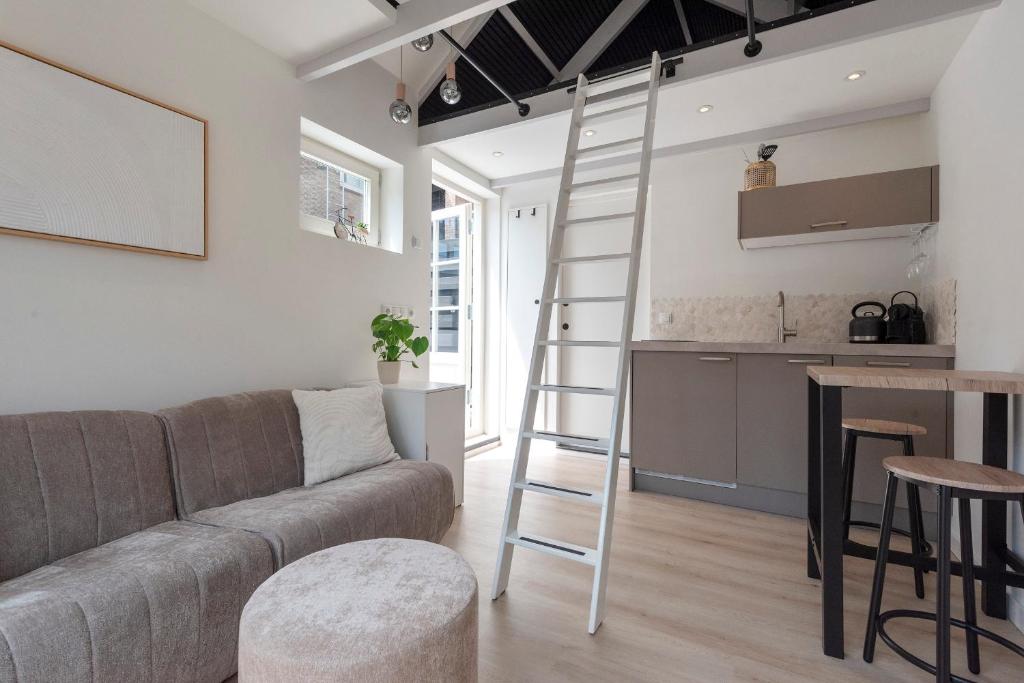 ein Wohnzimmer mit einem Sofa und einer Leiter in der Unterkunft Flamingo Beach Apartments in Zandvoort