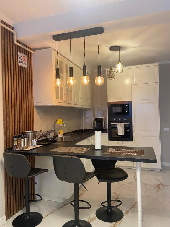 a kitchen with a counter with chairs and a microwave at F&Lrelax-Apartamente de închiriat aproape de plajă in Mamaia Nord