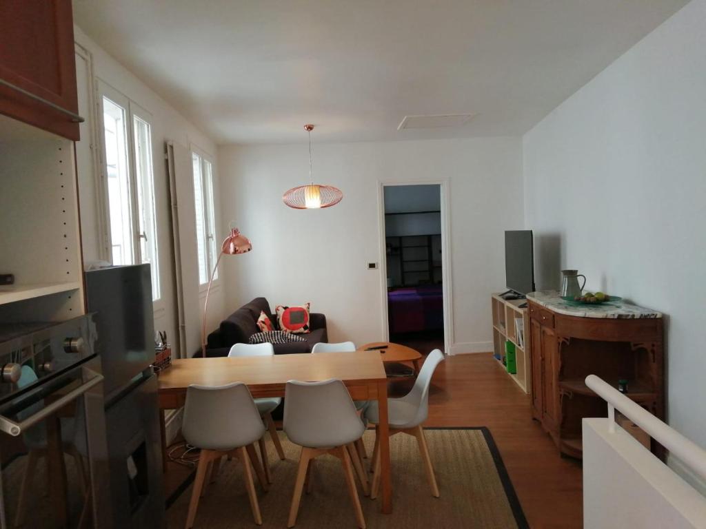 Una cocina y una sala de estar con mesa y sillas. en Damalix, en Saint-Maurice