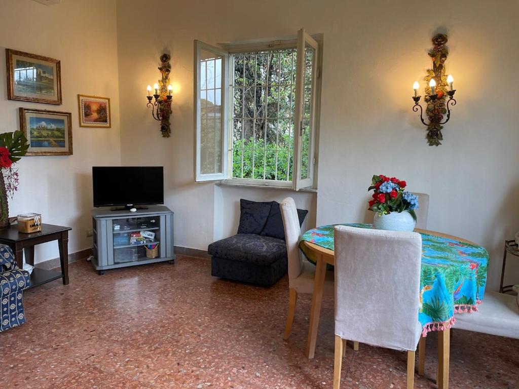 a living room with a table and a television at Villetta delle Acacie in Pisa