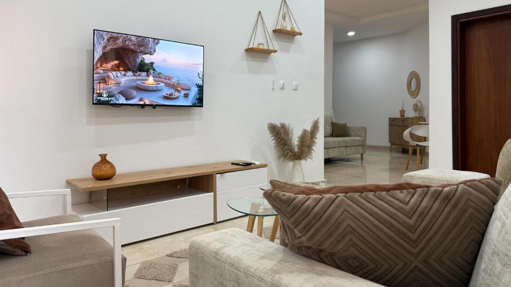 een woonkamer met een tv aan de muur bij Jotis home in Abidjan