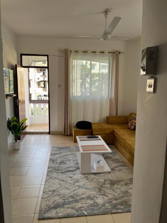 ein Wohnzimmer mit Sofa und Tisch in der Unterkunft Joy BNB in Mombasa