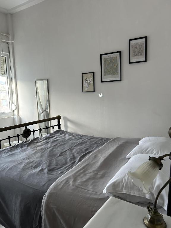 a white bedroom with a large bed with pillows at Moderna Yaya - Andros Chora in Andros