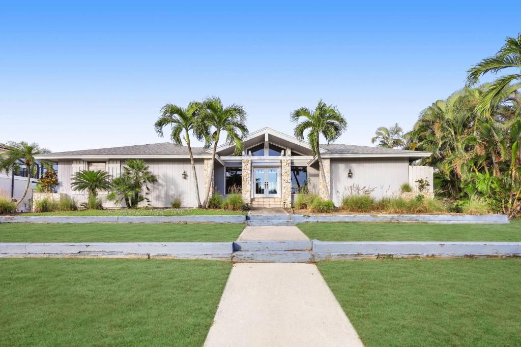 a house with palm trees in front of it at Boater’s paradise with unmatched water views in Marco Island
