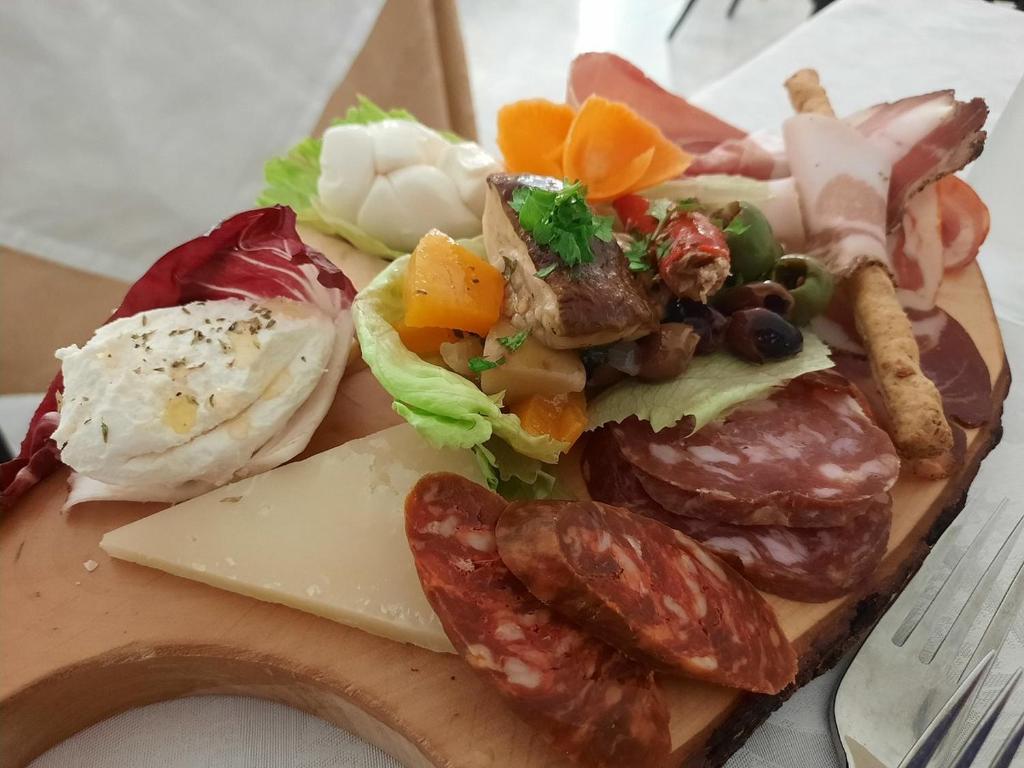 a plate of food with meat and vegetables on a cutting board at Hotel Ristorante Borgo La Tana in Maratea