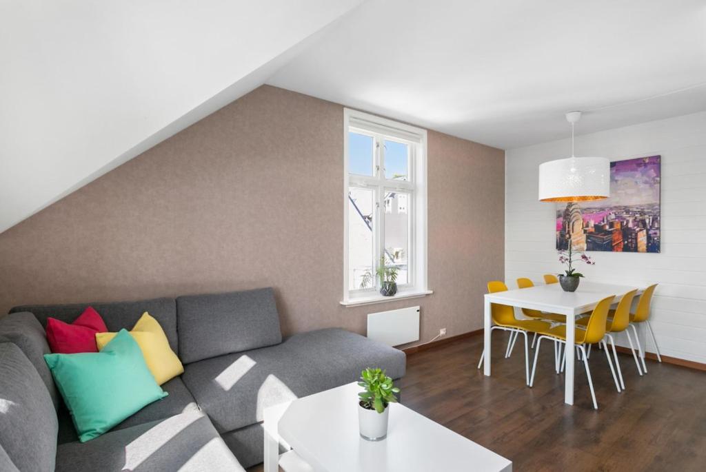 a living room with a couch and a table at Large apartment with 5 bedrooms, 2 bathrooms and roof terrace in Ålesund
