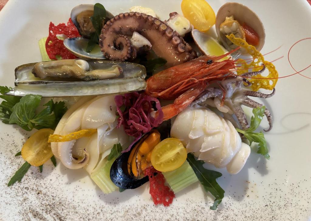 a white plate of food with seafood on it at Hotel Ristorante Borgo La Tana in Maratea