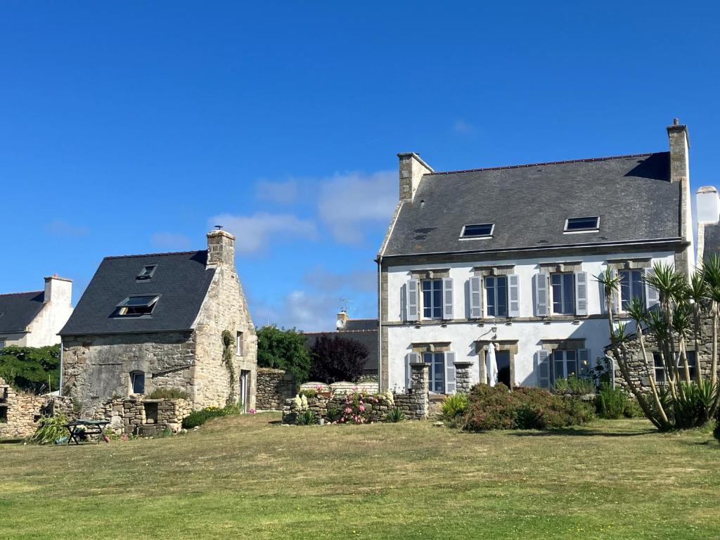 une ancienne maison en pierre avec deux cheminées sur un champ dans l'établissement Ty Traez, holiday house for families in Cap Sizun, à Primelin