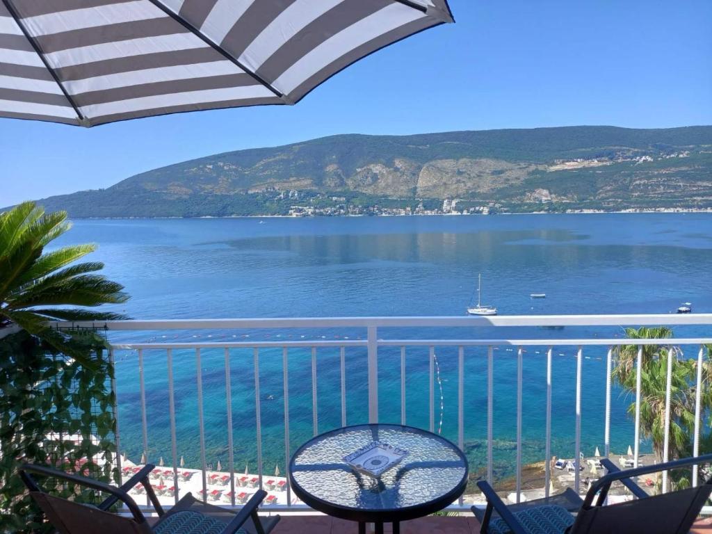 a balcony with chairs and a view of the water at Bay View Apartment in Herceg-Novi