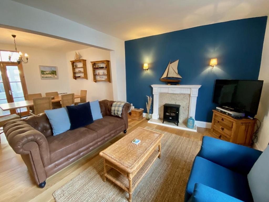 a living room with a couch and a fireplace at Killick Cottage in Sidmouth