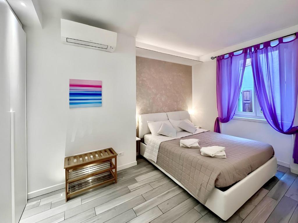 a bedroom with a bed and purple curtains at 1Dest - Hibiscus Home Arco in Arco