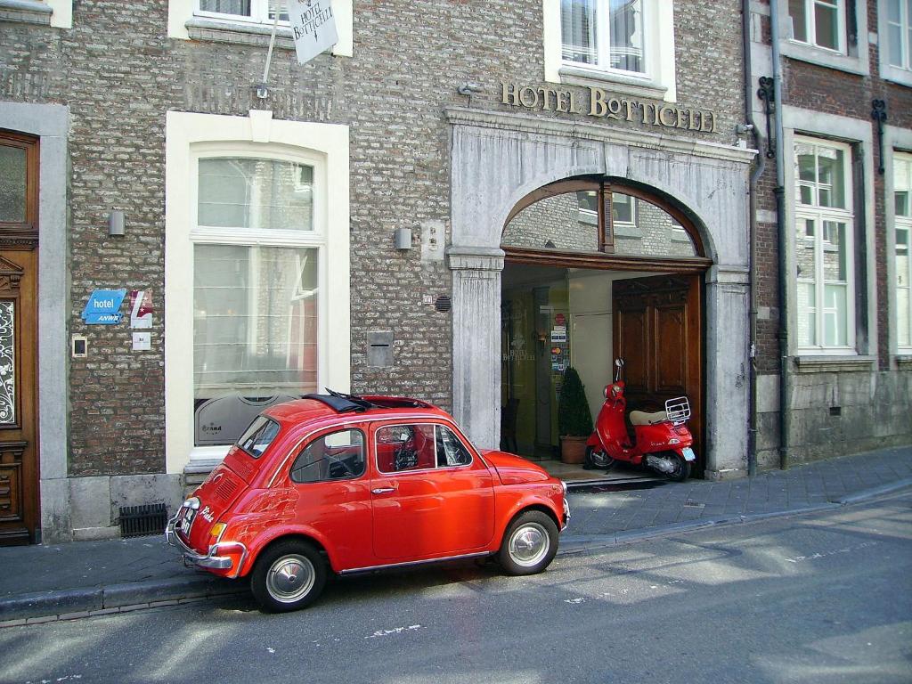 a red car parked in front of a red brick building at Hotel Botticelli in Maastricht