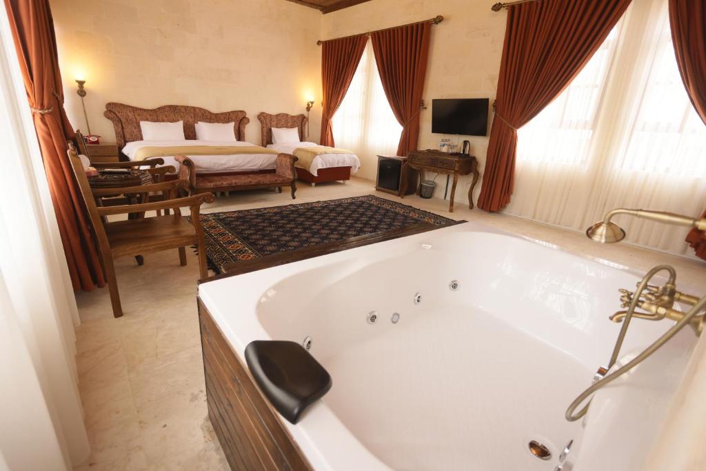 Un baño grande con bañera y un dormitorio. en Arangah Otel, en Sanlıurfa