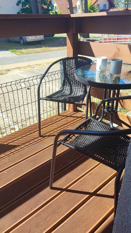 stół i krzesła na tarasie w obiekcie Apartamenty Poddąbek- basen kryty, sauna, animacje dla dzieci , małpi gaj, baseny na dachu w Poddąbiu