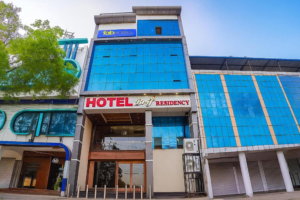 a hotel with a sign on the front of a building at FabHotel Brij Residency - hoshangabad , Near barkatullah university in Naiāpura