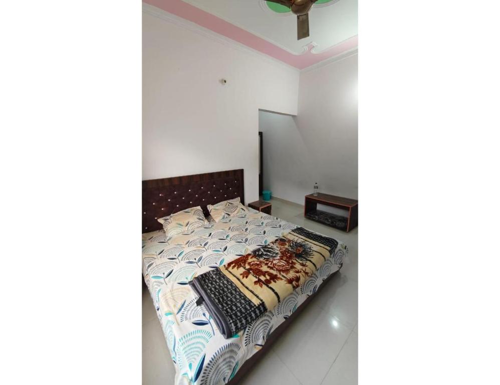 a bedroom with a bed with a comforter at casbio hotels in Rudraprayāg