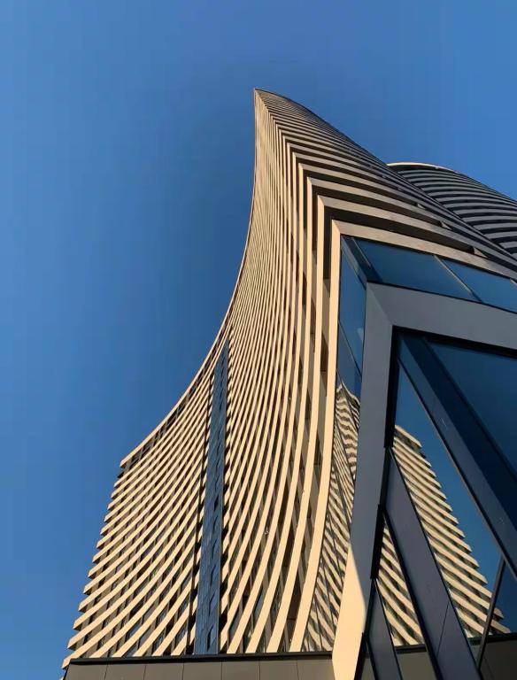 a tall building with a blue sky in the background at Skyline Residence Sarajevo Tower in Sarajevo