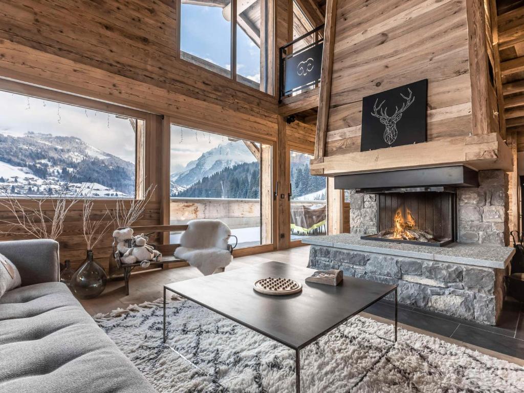 un salon avec un canapé et une cheminée dans l'établissement Chalet 5*, 5 chambres, SPA et sauna, proche pistes - FR-1-304-229, à La Clusaz