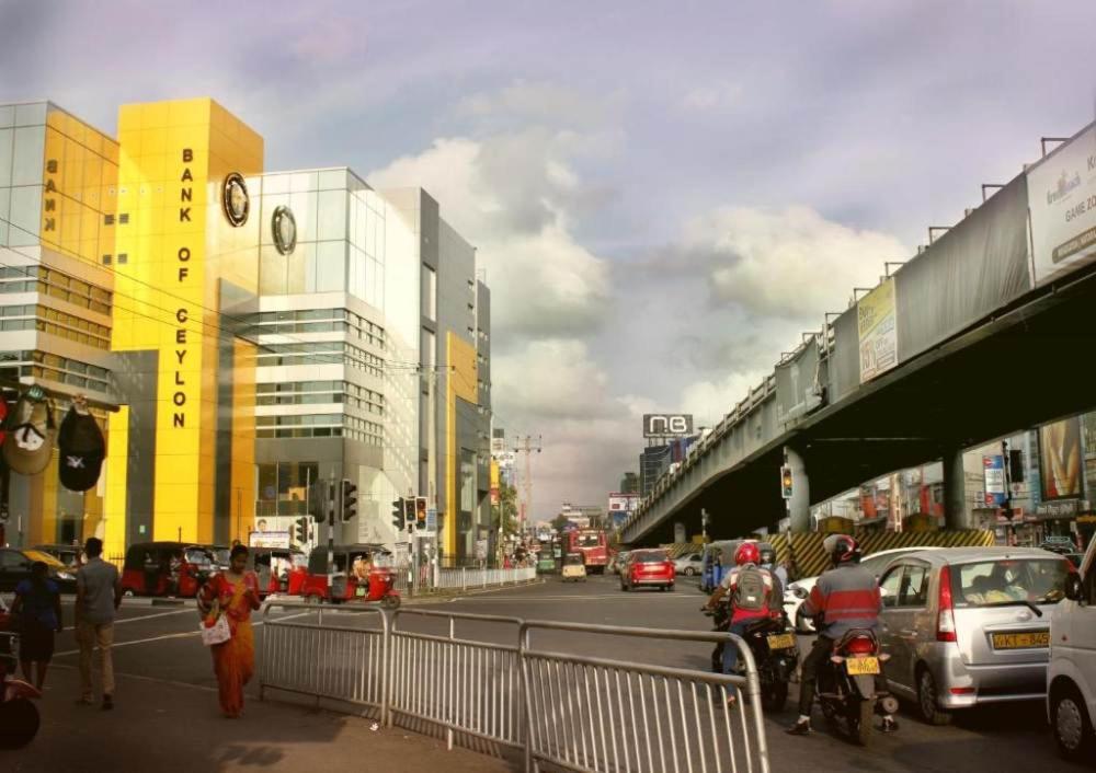 a busy city street with cars and motorcycles on the road at Thida House in Nugegoda
