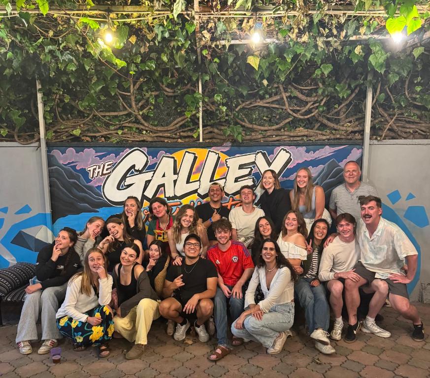 a group of people posing for a picture in front of a sign at The Galley Party Hostel in Shkodër
