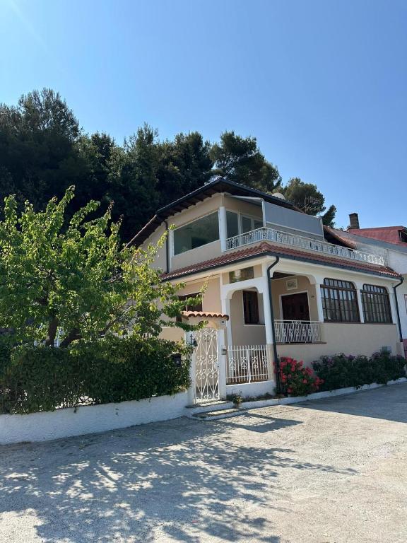 a large white house with a balcony on a street at Villa Lollo in Camporosso